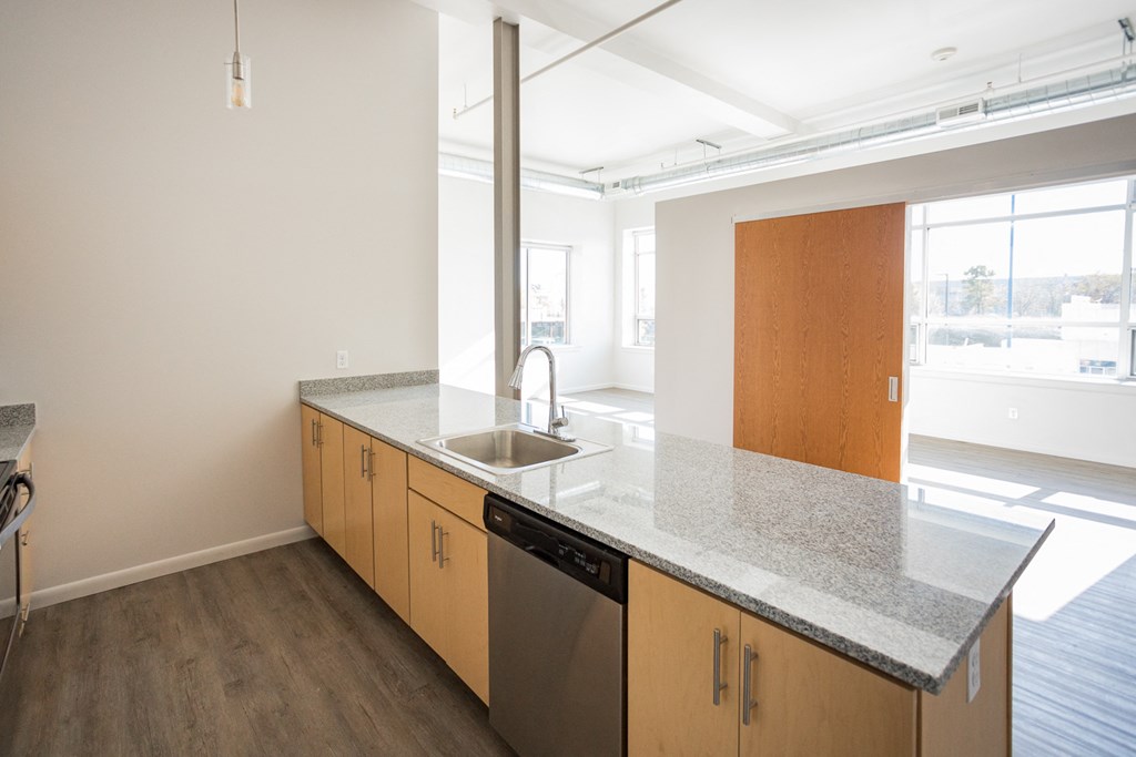 A kitchen with a granite countertop and wooden cabinets.