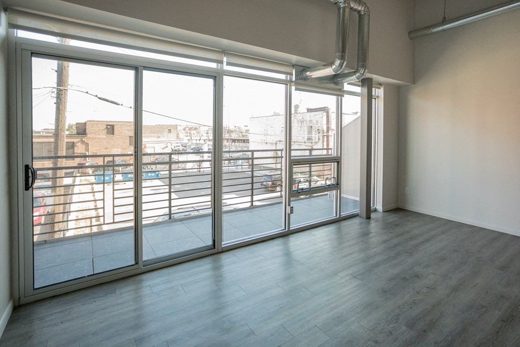 A room with a view of a parking lot through the windows.