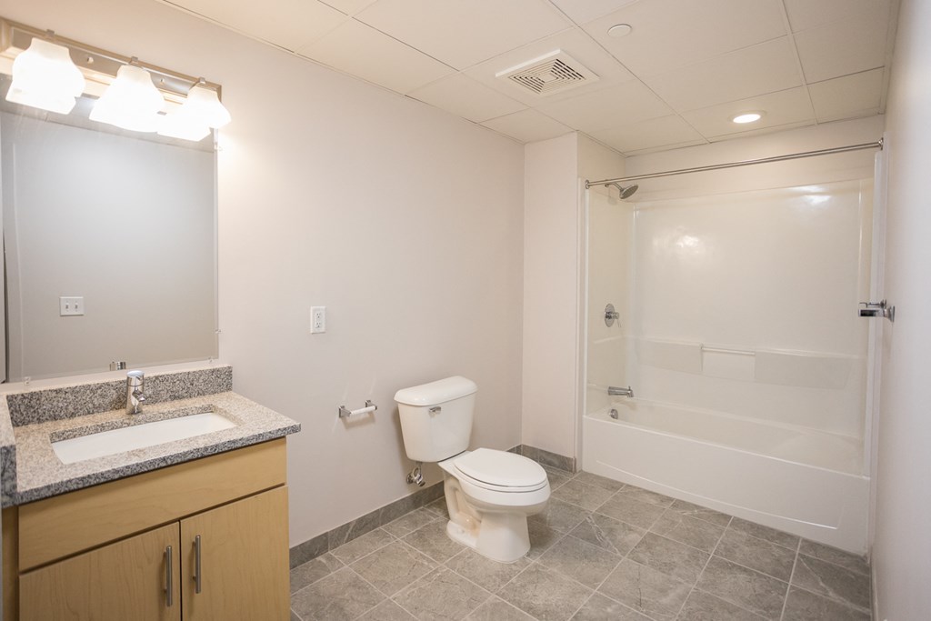 A bathroom with a toilet, sink, and shower.