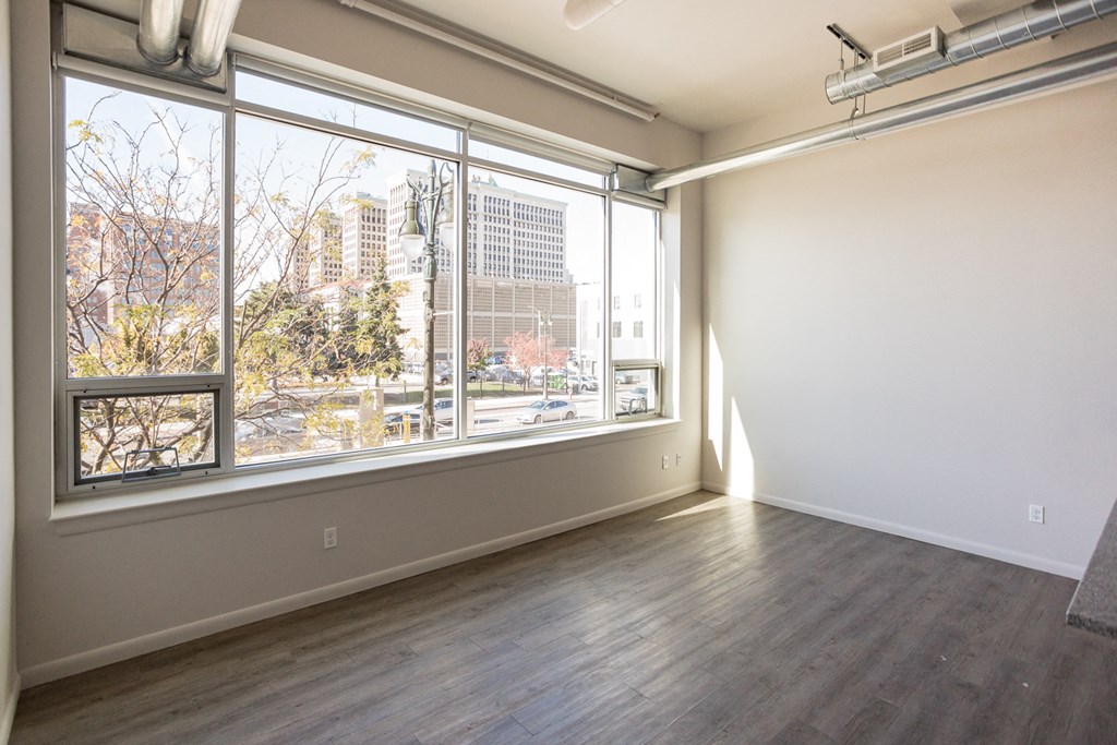 A large empty room with a view of the city through the windows.