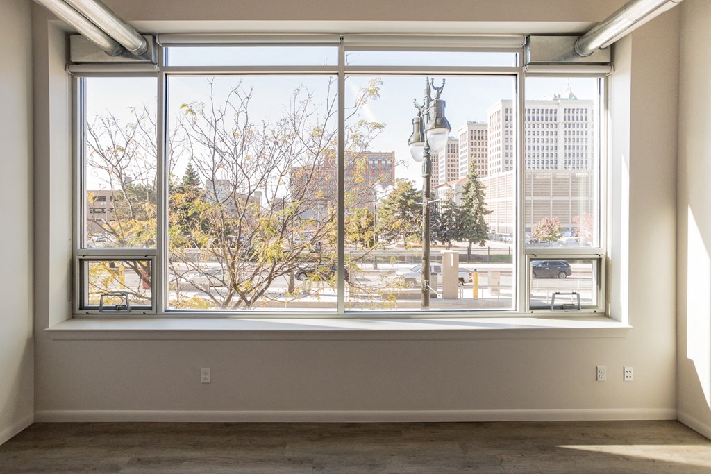 A room with a large window overlooking a city street.