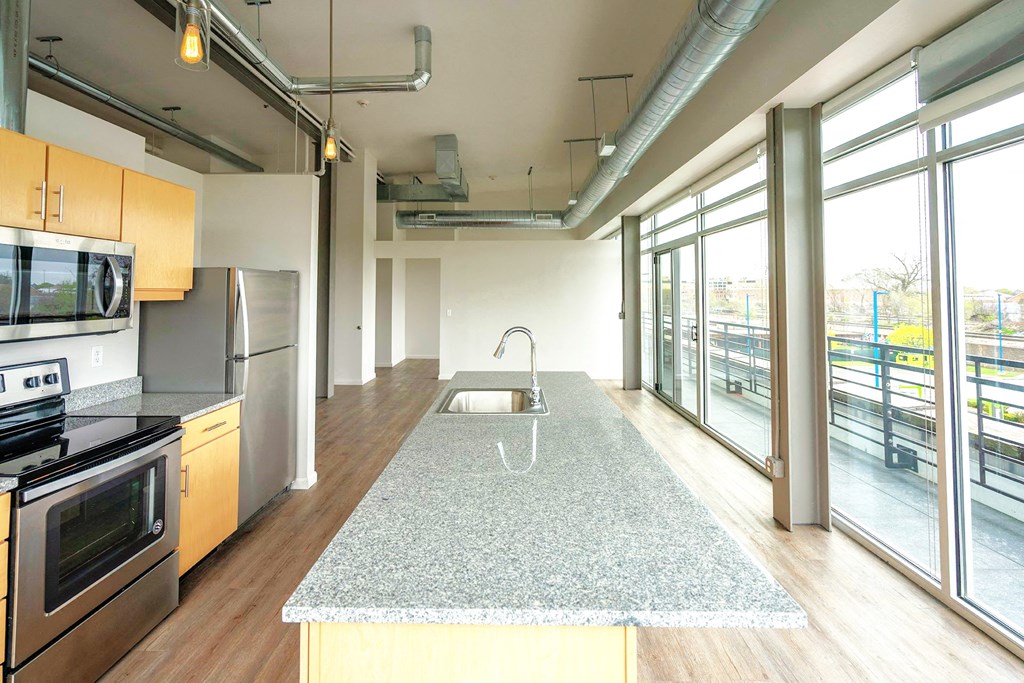A kitchen with a granite countertop and stainless steel appliances.