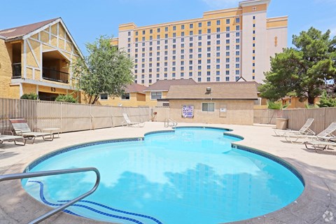 A large swimming pool in front of a hotel.