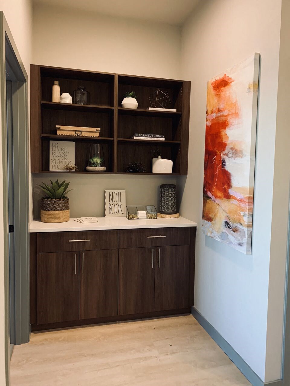 a room with a desk and shelves in it