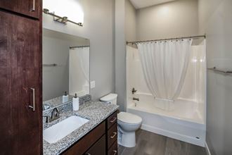 a bathroom with a toilet sink and bathtub  at RoCo Apartments, Fargo, ND