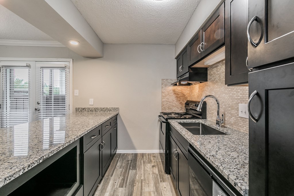Kitchen with dark wood cabinetry and modern backsplash