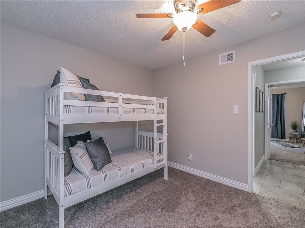 Bedroom with large window and ceiling fan in Riata Park Apartment