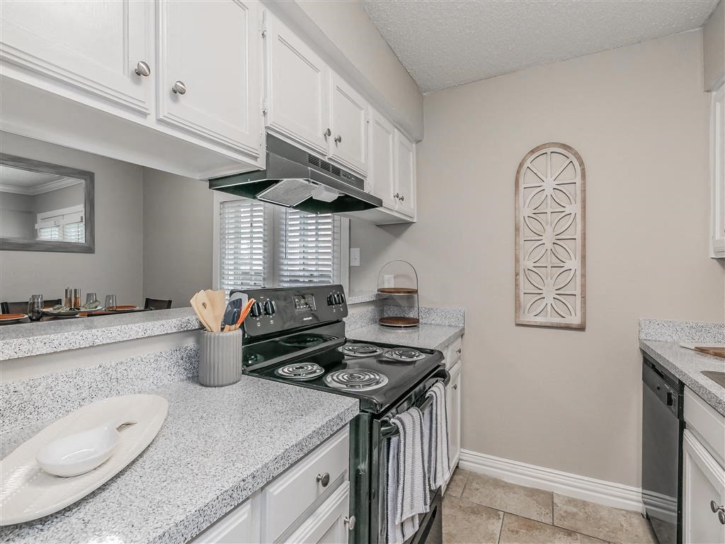 Apartment kitchen featuring upgraded appliances and lighting