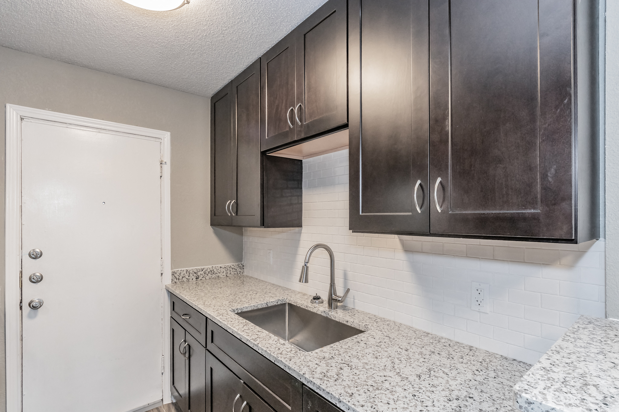 the kitchen of our studio apartment atrium with granite counter tops and dark cabinets