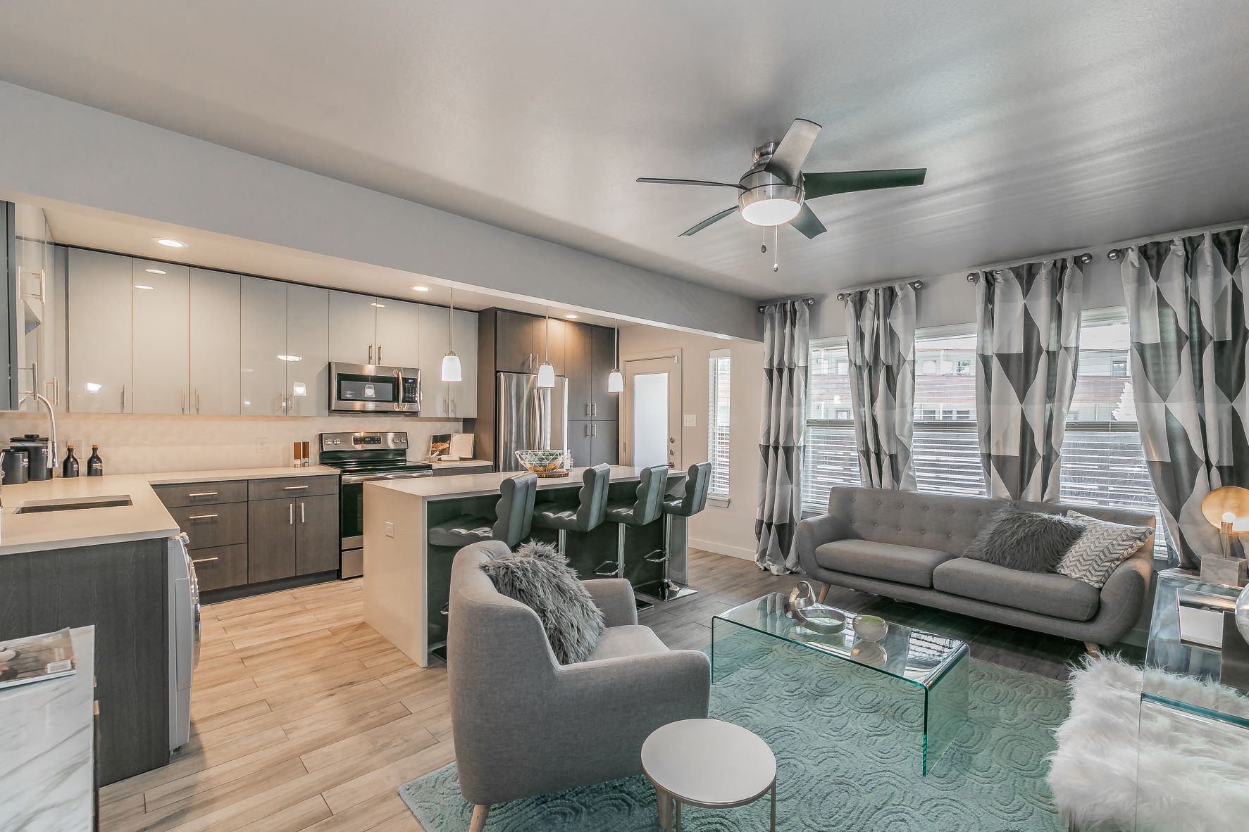 a living room and kitchen with couches and chairs
