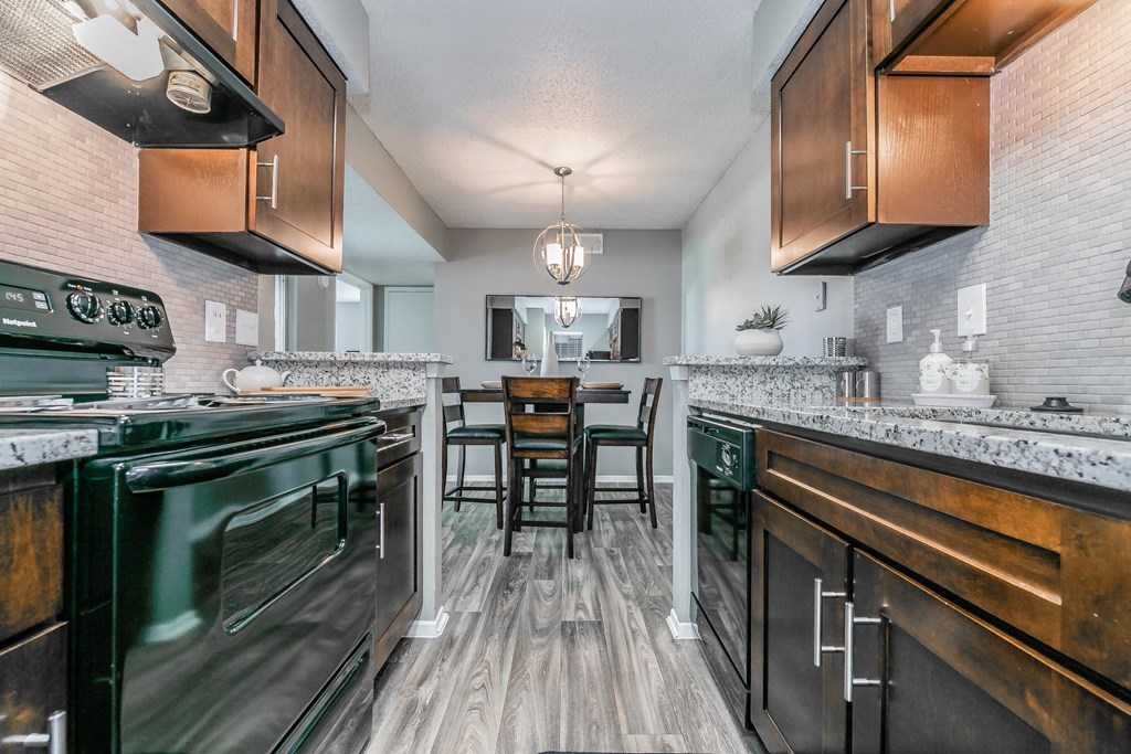 Kitchen with granite countertops, stainless steel appliances, and bar seating at Station 121 Apartments
