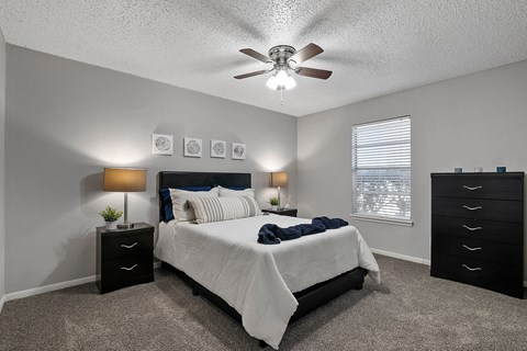 Bedroom with ceiling fan, carpet flooring, and window at Sage Creek Apartments