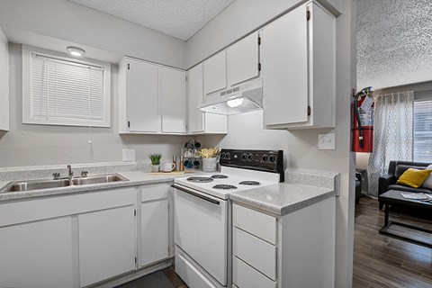 White kitchen with refrigerator, oven, and ample cabinets
