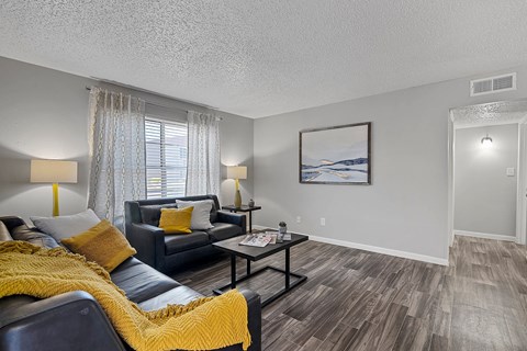 Living room with accent chair, sofa, and bright windows