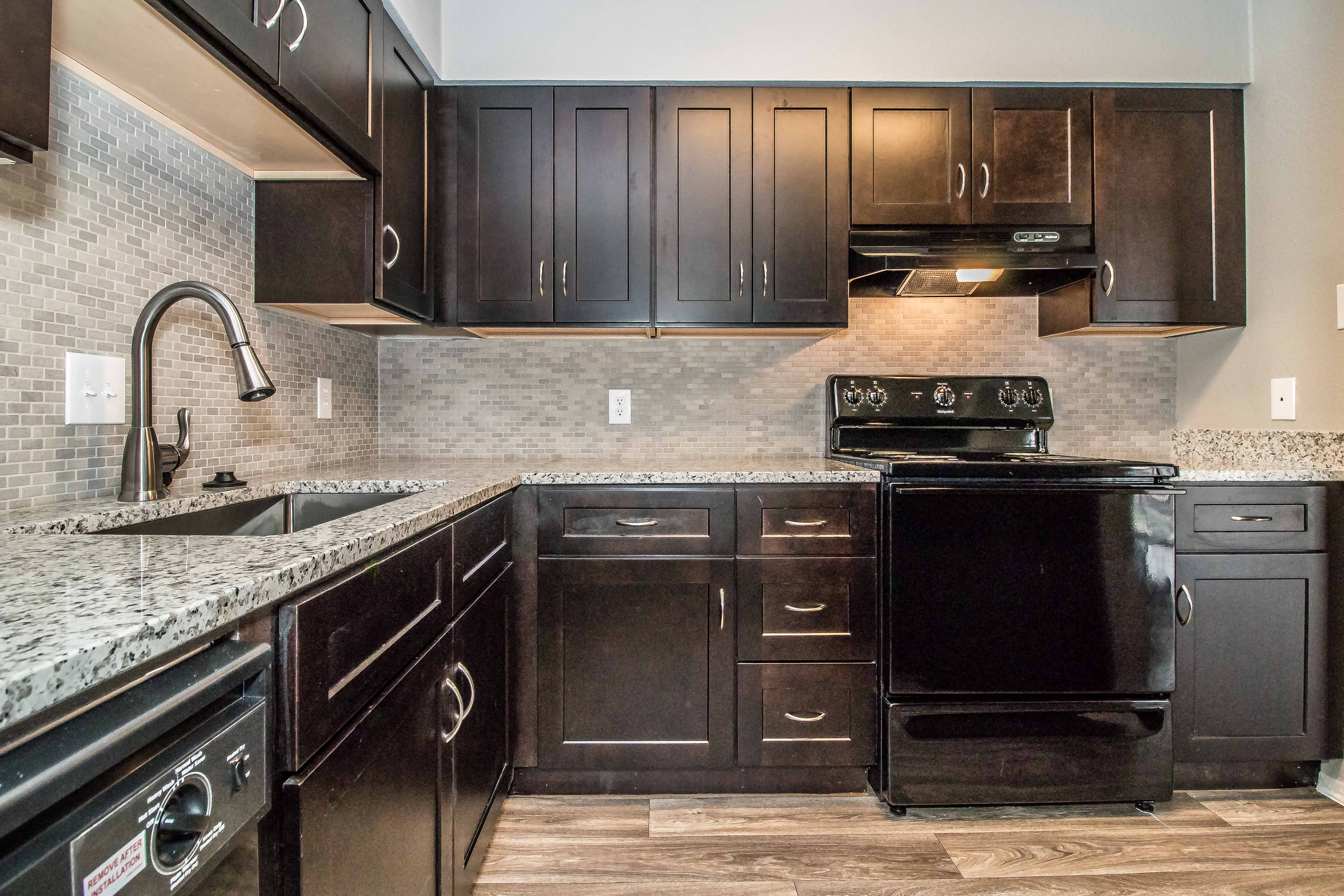a kitchen with black appliances and dark wood cabinets