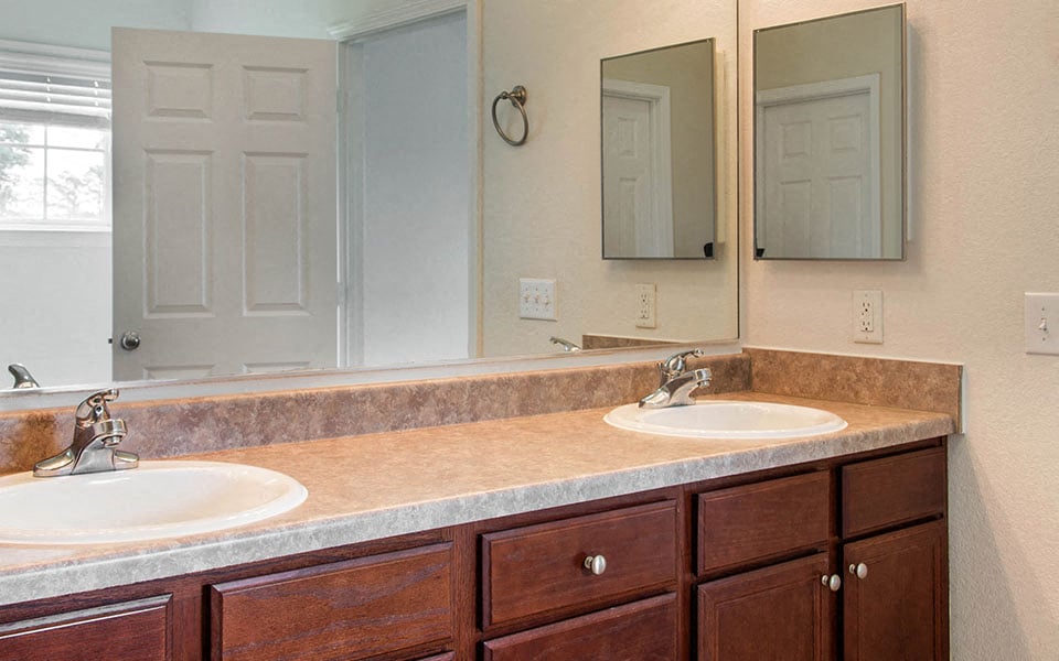 a bathroom with two sinks and two mirrors