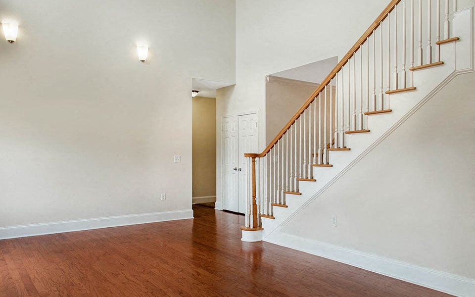 a staircase in a house with wood floors and white walls