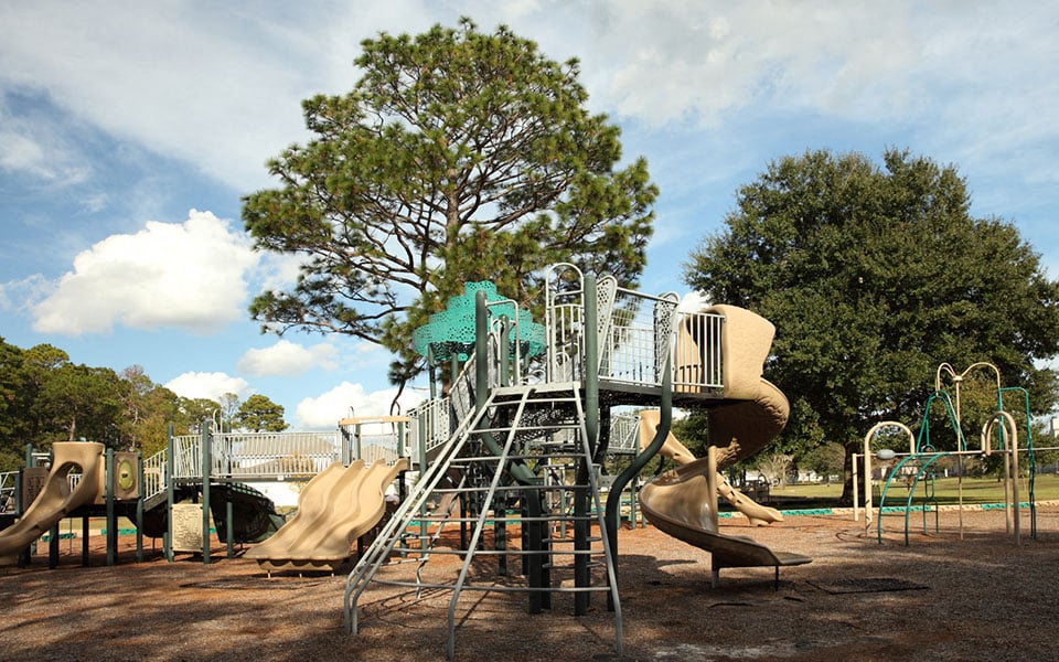 a playground with slides and climbing equipment in a park
