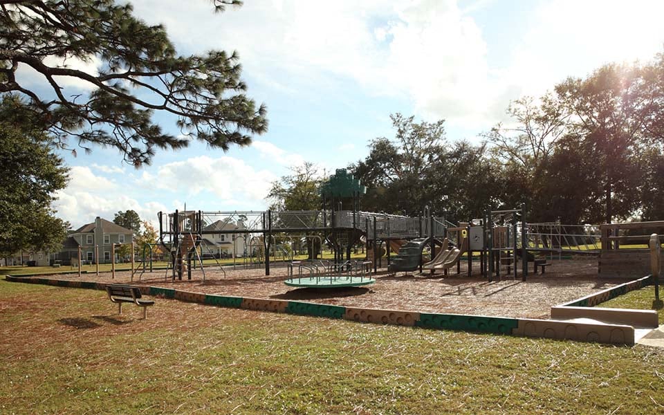 a playground with a swing set and a sandbox