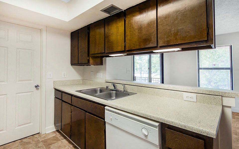 a kitchen with a sink and cabinets and a window