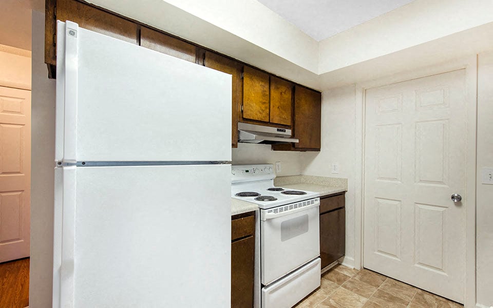 a kitchen with a white refrigerator and a stove