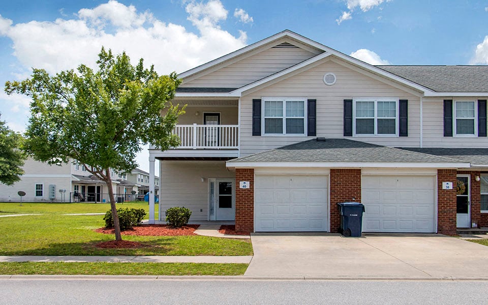 a house with a garage and a tree in front of it
