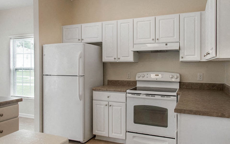 a kitchen with white appliances and white cabinets