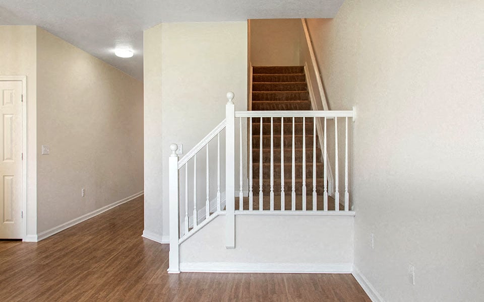 a white staircase in a house with a white wall and stairs