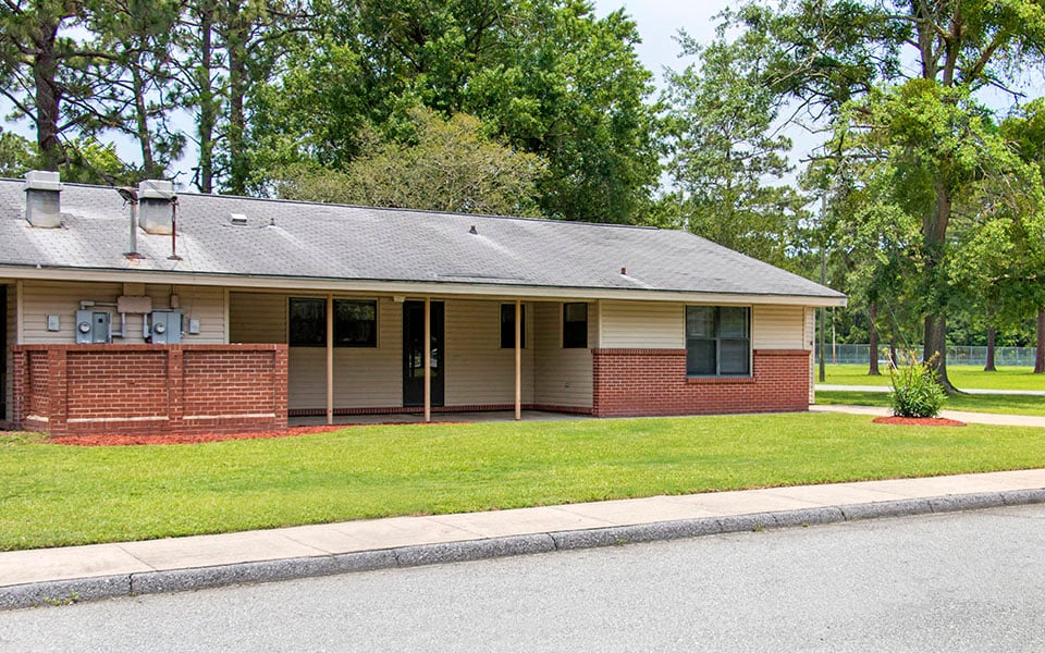 the front of a brick house on the side of a street