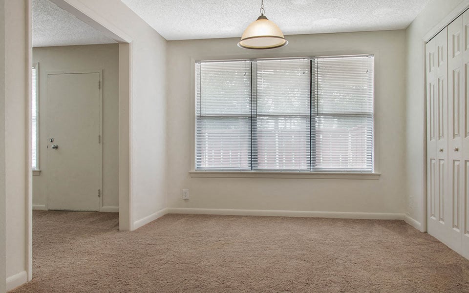 an empty room with a large window and a closet