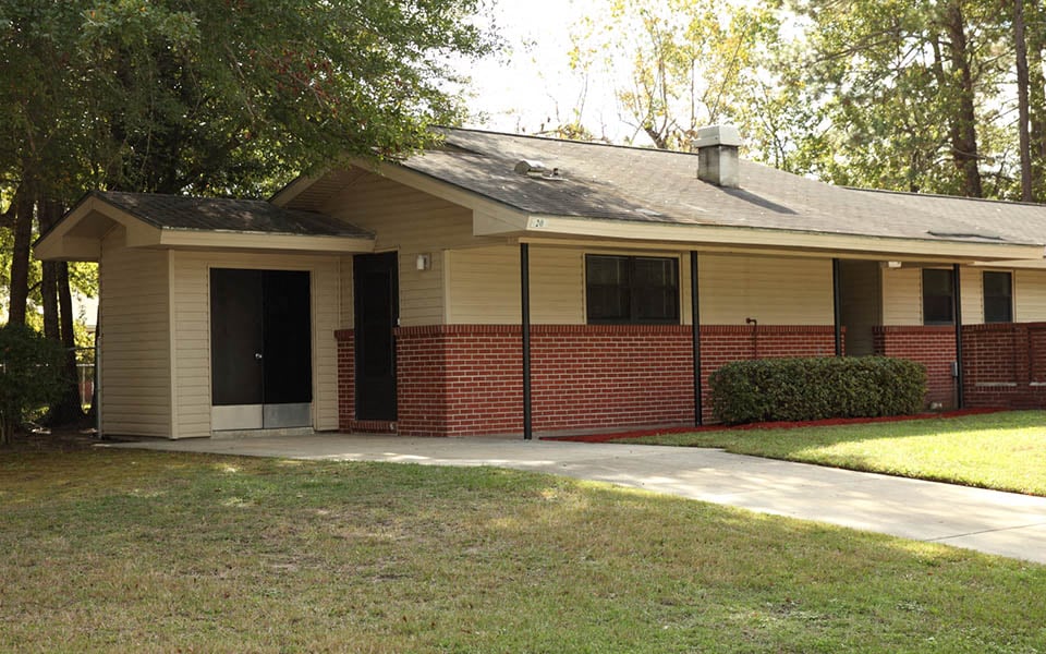 a brick house with a sidewalk in front of it