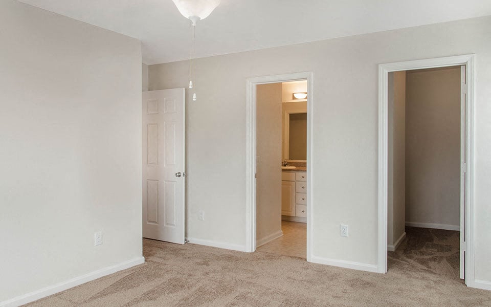 a bedroom with a closet and a door to a bathroom