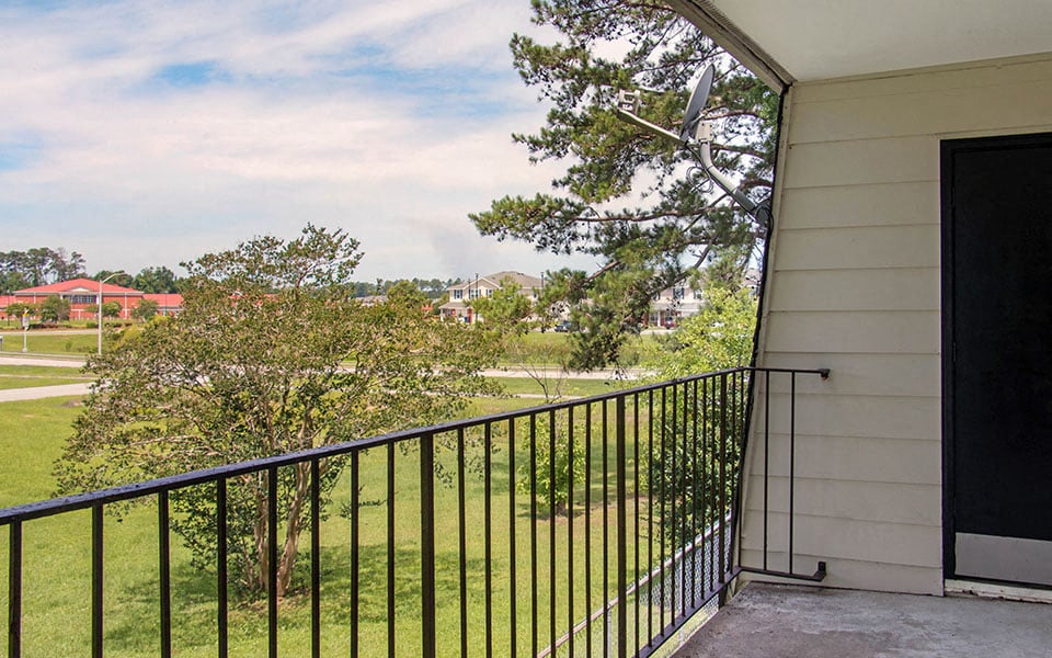 a balcony with a view of a yard and a house