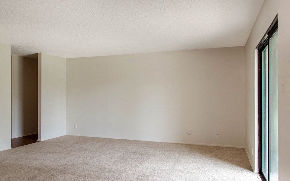 an empty living room with a sliding glass door