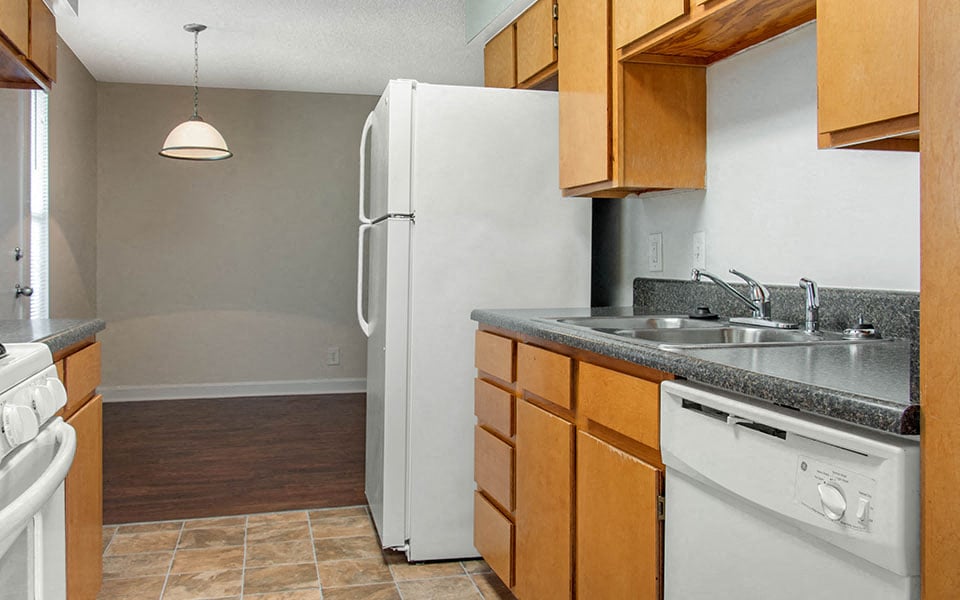 a kitchen with a white refrigerator and a sink
