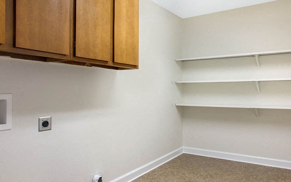 an empty room with white walls and cabinets and shelves