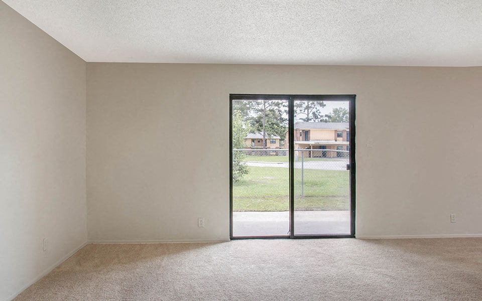 an empty living room with a sliding glass door