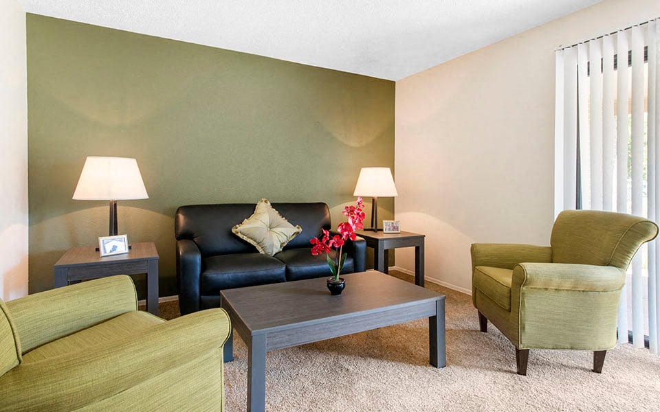 a living room with a couch and chairs and a table