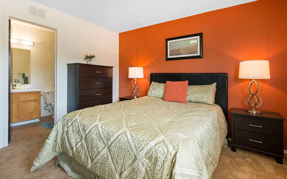 a bedroom with a bed and a bathroom with a sink