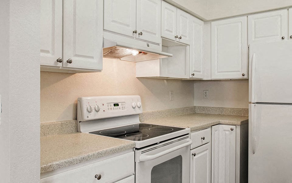 a white kitchen with white appliances and white cabinets