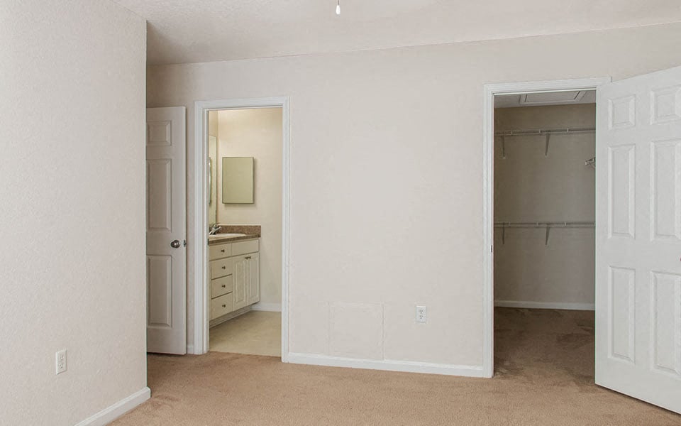 an empty room with a bathroom and a closet