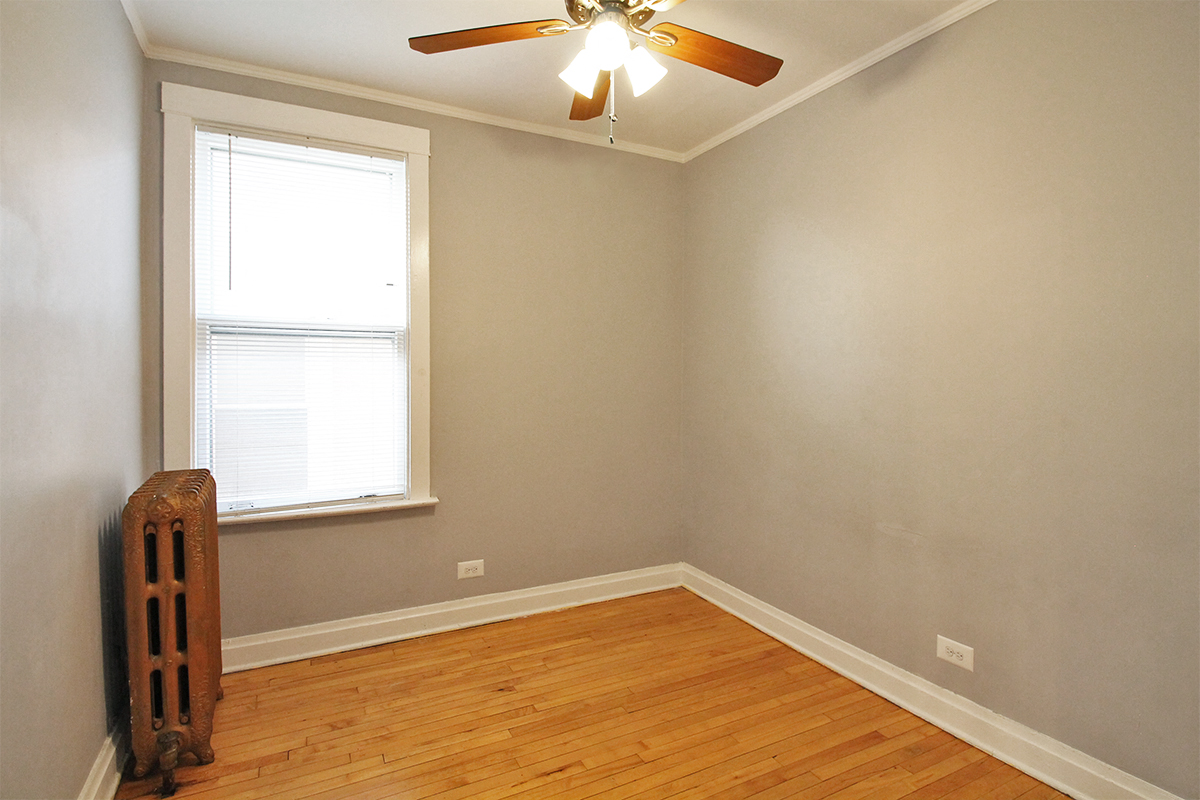 an empty room with a ceiling fan and a window