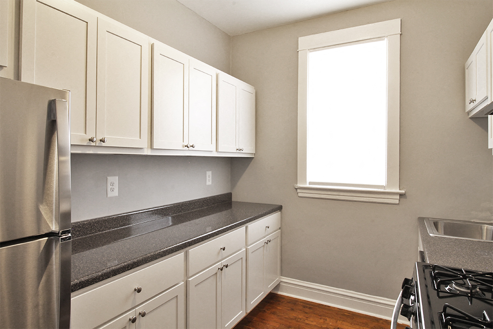 a kitchen with white cabinets and a stainless steel refrigerator