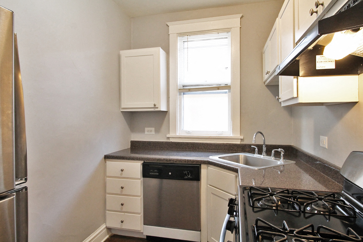 a kitchen with a stove and sink and a window