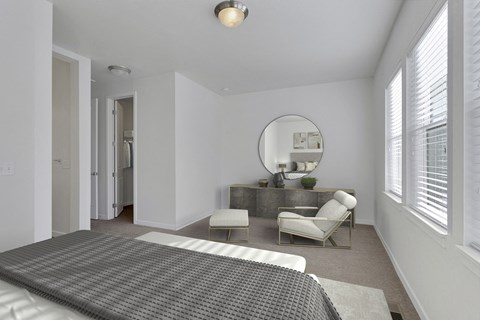 a bedroom with white walls and a bed and a mirror