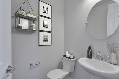 a white bathroom with pictures on the wall and a toilet and sink
