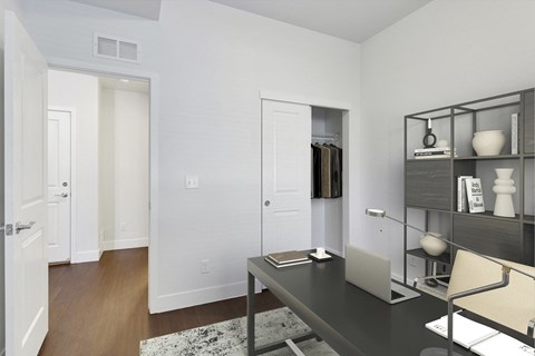 a home office with a desk and a door to a closet