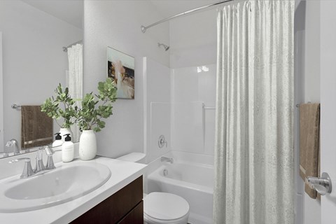a bathroom with a white sink and a tub and a shower