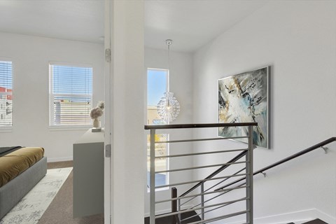a living room with a staircase and a view of a bedroom and a window