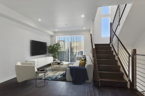 a living room with white furniture and a staircase